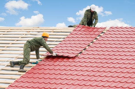 Contractors installing metal roof sheets